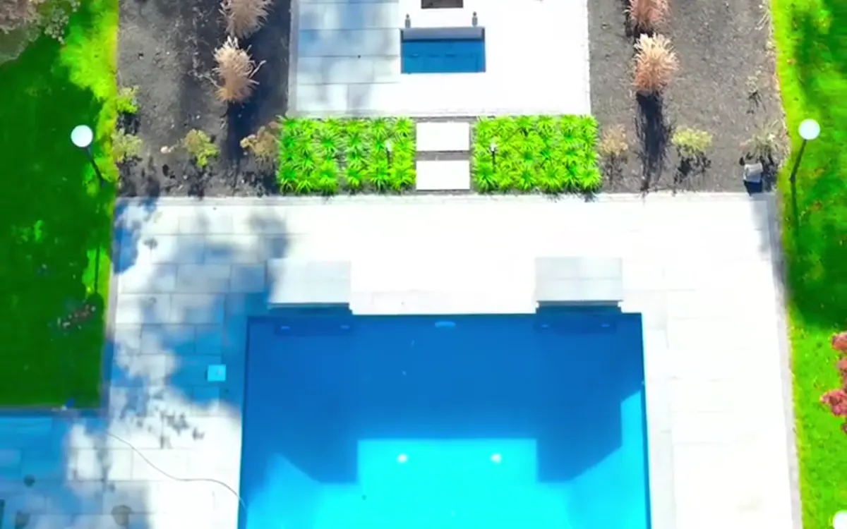 Garden beds, lawn and poolside patio in a residential outdoor space